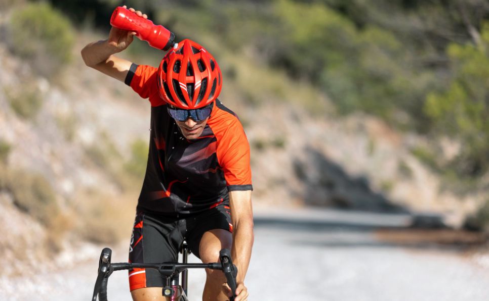 cycliste s'arrose avec sa gourde sous la chaleur